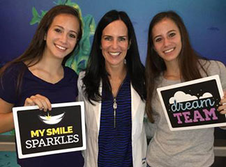 Dr. Statlet with two teenage patients that have completed treatment.
