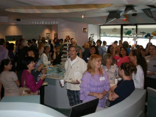 Crowded dental office reception area with patients and staff gathered for an event or appointment.