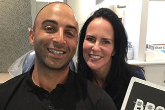 Two smiling professionals pose together indoors at Statler Orthodontics office setting.