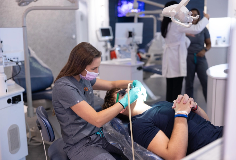 Orthodontist examining patient's teeth during dental appointment in modern clinic setting.