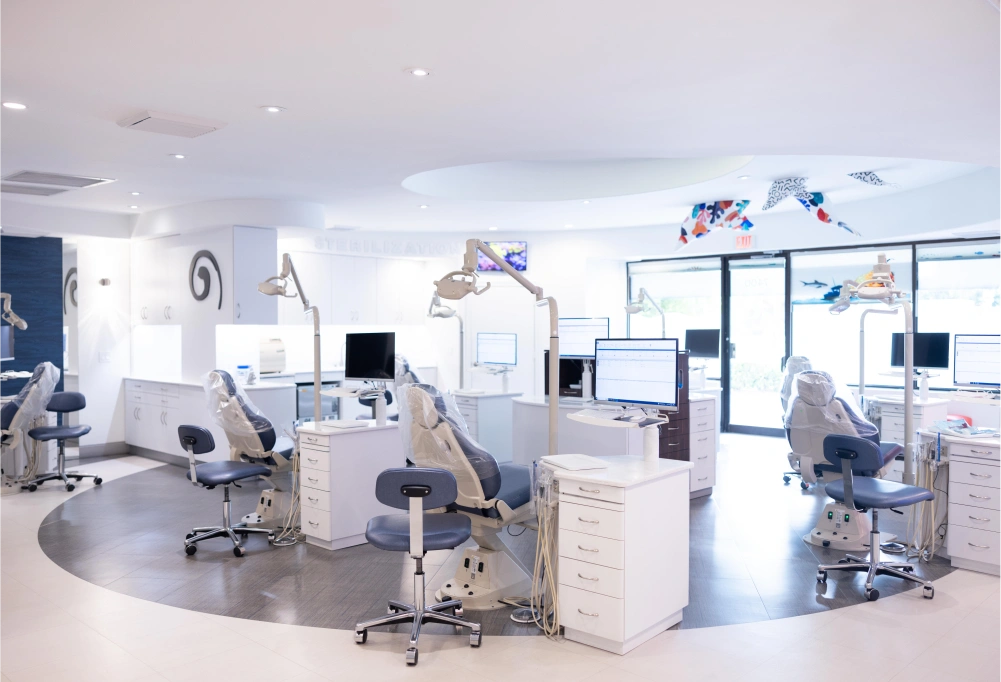 Modern orthodontic office interior with dental chairs, equipment, and bright clinical workspace.
