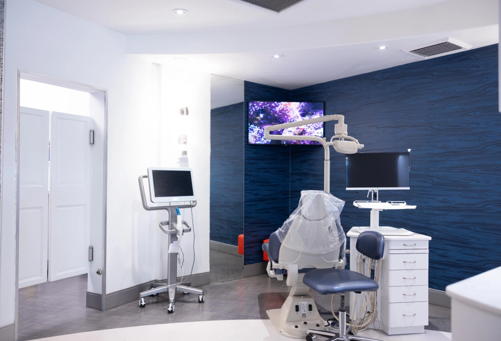 Modern orthodontic treatment room with dental chair, equipment, and blue accent wall at Statler Orthodontics.
