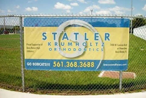Statler Krumholtz Orthodontics outdoor sign with contact information displayed on blue and yellow banner.
