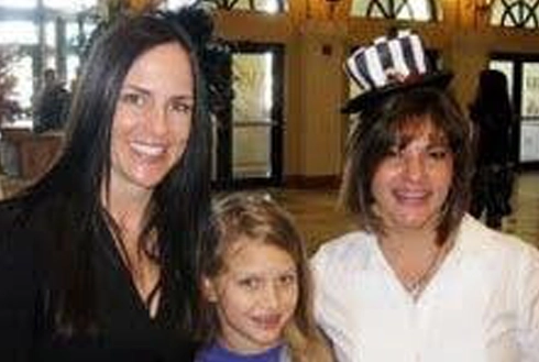 Three people posing together indoors at what appears to be an orthodontics office or event.