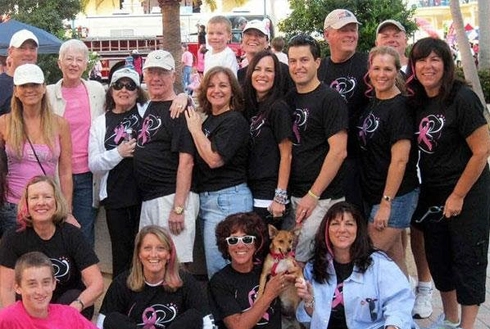 Large group of people wearing matching black shirts at outdoor community event or fundraiser.