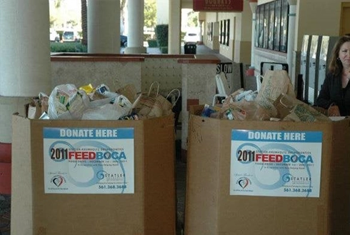 Two cardboard donation bins labeled "DONATE HERE" filled with collected items in an orthodontic office hallway.