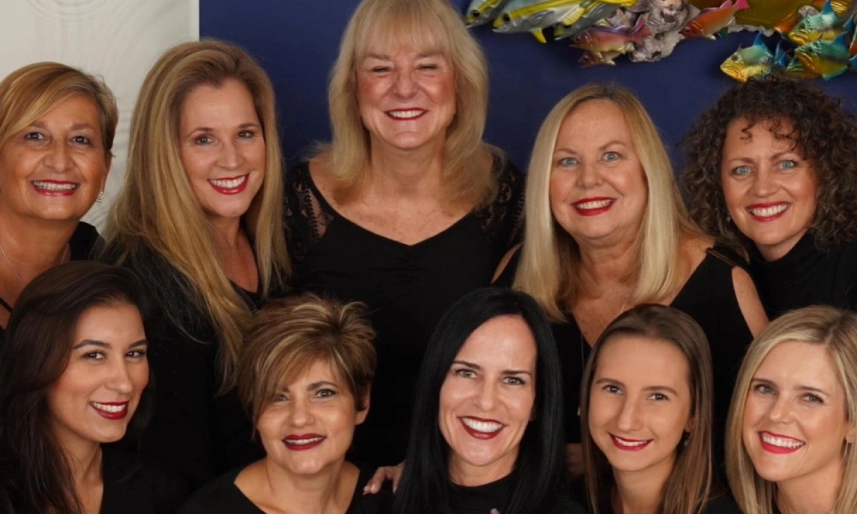 Group portrait of smiling women staff members at Statler Orthodontics, posed together indoors.
