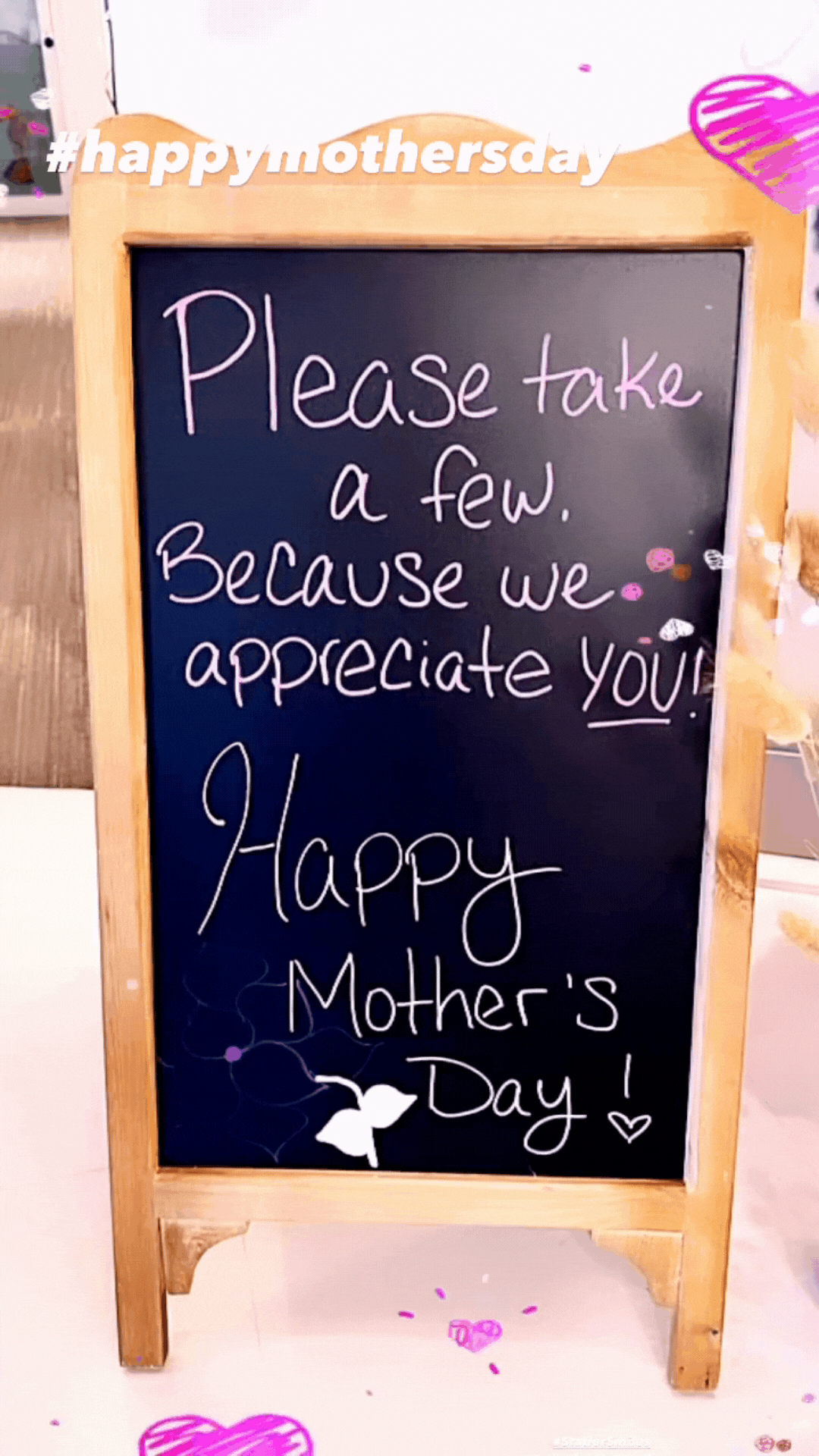 Wooden sandwich board with Mother's Day message offering complimentary services in orthodontic office.